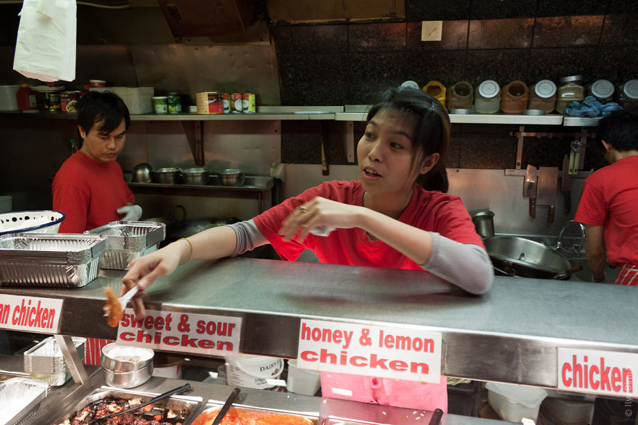 Девушка предлагает посетителю рынка в Кемден-тауне попробовать курицу