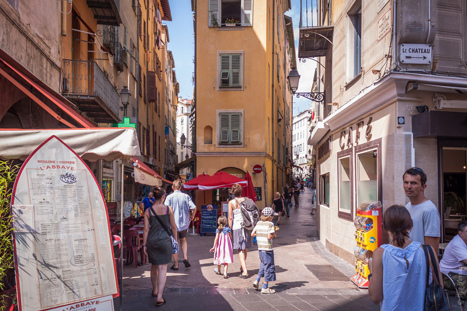 Люди, мотороллеры, столики и машины легко уживаются на улочках Ниццы