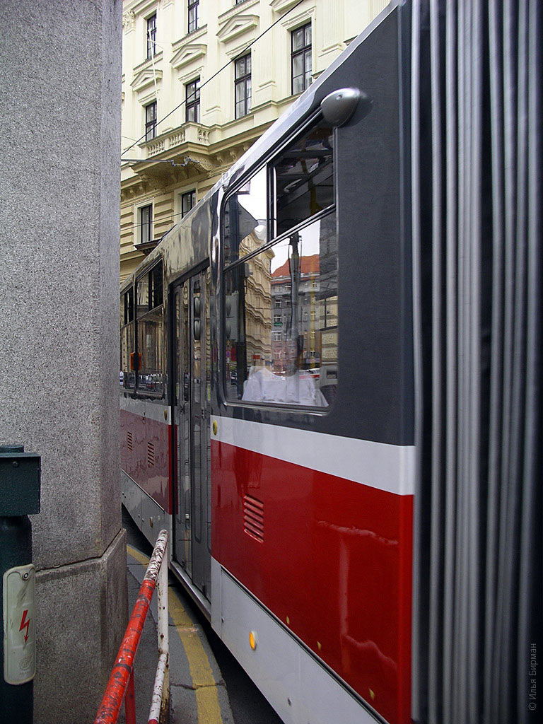 Трамвай поворачивает с одной узкой улочки на другую, проезжая всего сантиметрах в тридцати-сорока от угла дома
