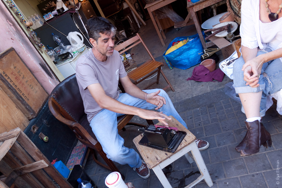 Мужик протирает арифмометр на блошином рынке в Яффе рядом с Тель-Авивом