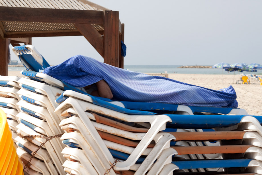 Человек спит на пляже Тель-Авива